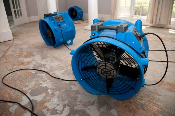 Large air movers drying an exposed subfloor